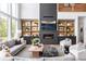 Cozy living room featuring a fireplace, built-in shelving, hardwood floors and natural light from large windows at 4825 Gadwall Way, Cumming, GA 30028