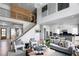 Open-concept living room with stairs, railing, high ceilings, decor art, hardwood floors, and connection to the kitchen area at 4825 Gadwall Way, Cumming, GA 30028