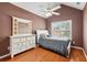 Bedroom with brown accent walls, hardwood floors, and a large window at 10300 Medridge Cir, Johns Creek, GA 30022