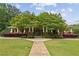 A view of the clubhouse featuring well maintained landscaping, a covered porch, and ample curb appeal at 10300 Medridge Cir, Johns Creek, GA 30022