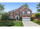 Charming two-story brick home featuring a well-manicured lawn and an attached two-car garage at 10300 Medridge Cir, Johns Creek, GA 30022