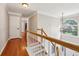 Upstairs hallway and staircase with hardwood floors, white railings, and natural light at 10300 Medridge Cir, Johns Creek, GA 30022