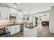 Well-lit kitchen with island that opens to living room with stone fireplace and dark brown sofa at 10300 Medridge Cir, Johns Creek, GA 30022