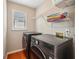 Modern laundry room featuring a front-load washer and dryer, plus shelving for storage at 10300 Medridge Cir, Johns Creek, GA 30022