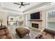 Spacious living room with fireplace and mounted TV flowing to the kitchen with island and stainless steel appliances at 10300 Medridge Cir, Johns Creek, GA 30022
