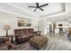 Open-concept living space with a comfortable brown sofa, adjacent to a modern kitchen at 10300 Medridge Cir, Johns Creek, GA 30022