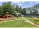 Outdoor community playground with slides, clubhouse, and tennis court surrounded by lush green space at 10300 Medridge Cir, Johns Creek, GA 30022