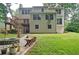 Backyard view showcasing a multi-level home with a deck, patio, lush lawn, and cozy firepit area at 2212 Mcquiston Sw Dr, Marietta, GA 30064