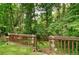 Wooden railing and stairs in backyard with lush greenery, and a fire pit, creating a private retreat at 2212 Mcquiston Sw Dr, Marietta, GA 30064