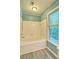Renovated bathroom featuring a bathtub with shower and window view at 2212 Mcquiston Sw Dr, Marietta, GA 30064