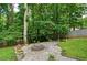 Backyard fire pit with seating is perfect for gatherings and relaxation surrounded by lush trees at 2212 Mcquiston Sw Dr, Marietta, GA 30064