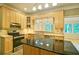 Bright eat-in kitchen features stainless appliances, light wood cabinets, tile floor and a black island at 2212 Mcquiston Sw Dr, Marietta, GA 30064