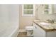 Bathroom with tiled tub, modern sink with granite countertop and wood-look flooring at 2912 Springside Se, Atlanta, GA 30354