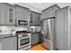 Modern kitchen featuring stainless steel appliances, gray cabinets, and granite countertops, perfect for cooking and entertaining at 3541 Roswell Ne Rd # 21, Atlanta, GA 30305