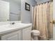Cozy bathroom with a toilet, sink, and shower with a patterned curtain at 1951 Chambers Rd, Mcdonough, GA 30253