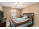Bedroom featuring a bed with a blue comforter, a ceiling fan, and a dresser with a TV at 1951 Chambers Rd, Mcdonough, GA 30253