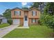 Two-story home with a well-manicured lawn, a convenient garage, and charming curb appeal at 5653 Bradley Cir, Lithonia, GA 30038