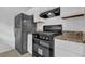 Kitchen with granite countertops, white cabinets, and modern stainless steel range at 5653 Bradley Cir, Lithonia, GA 30038