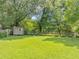 Large backyard with a storage shed, flower beds, chain link fence and established trees at 701 Green Acres Se Rd, Smyrna, GA 30080