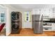 Convenient laundry area with stacked washer and dryer, next to stainless steel refrigerator and cabinets at 701 Green Acres Se Rd, Smyrna, GA 30080