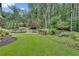 Professionally landscaped backyard with lush green grass, plants, trees, and patio set at 114 Trinity Hollow Dr, Canton, GA 30115