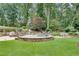 Expansive backyard with lush green lawn, stone terrace, and waterfall pool at 114 Trinity Hollow Dr, Canton, GA 30115