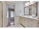 Bright bathroom featuring a white vanity with drawers, decorative mirror, and access to the backyard at 114 Trinity Hollow Dr, Canton, GA 30115