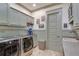 Functional laundry room with modern appliances, sage green cabinets, and countertop space at 114 Trinity Hollow Dr, Canton, GA 30115