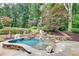 Inviting pool with stone waterfall and surrounding landscaping at 114 Trinity Hollow Dr, Canton, GA 30115
