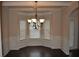 Bright dining area with wainscoting, hardwood floors, and a chandelier next to a door that leads outside at 1530 Horseshoe Creek Ln, Cumming, GA 30041
