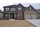 Charming two-story home with a brick and tan exterior, black shutters, and a covered front porch at 1530 Horseshoe Creek Ln, Cumming, GA 30041