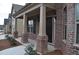 Inviting brick porch with classic columns and a dark-colored front door with black door hardware at 1530 Horseshoe Creek Ln, Cumming, GA 30041