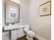 Elegant powder room featuring a pedestal sink, a wooden-framed mirror, and stylish wood flooring at 1993 Haley Walk, Atlanta, GA 30318