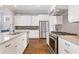 Modern kitchen with stainless steel appliances, white cabinets, granite countertops, and hardwood flooring at 1993 Haley Walk, Atlanta, GA 30318