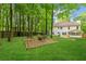 Large backyard with mature trees, a fire pit area, and a well-maintained lawn at 76 Barrington Farms Pkwy, Sharpsburg, GA 30277