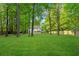 Expansive backyard featuring a lush green lawn and mature trees at 76 Barrington Farms Pkwy, Sharpsburg, GA 30277
