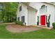 Charming white home featuring a bright red door, dark shutters, and manicured landscaping at 76 Barrington Farms Pkwy, Sharpsburg, GA 30277