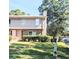 Two-story townhouse with brick facade, siding, and mature trees on a bright, sunny day at 1215 Willow Creek Nw Ct, Conyers, GA 30012