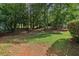 Tree-filled backyard with grass, dirt, and privacy at 3970 Genoa Ct, Duluth, GA 30096