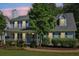 Charming two-story home featuring a covered porch, blue shutters, and lush greenery at 3970 Genoa Ct, Duluth, GA 30096