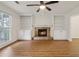 Inviting living room with a stone fireplace, built-in shelving, and a ceiling fan for added comfort at 3970 Genoa Ct, Duluth, GA 30096