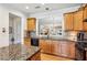 Open-concept kitchen with granite countertops and wood cabinetry, with a view to the living room at 5105 Kings Common Way, Cumming, GA 30040