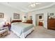 Comfortable main bedroom showcasing neutral walls, tray ceiling, and classic furnishings at 5105 Kings Common Way, Cumming, GA 30040