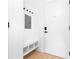 Bright entryway featuring a white bench with storage cubbies, hooks, and a modern front door at 567 Ponce De Leon Ne Ave # 321, Atlanta, GA 30308