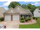 Charming single Gathering home featuring a two-car garage, manicured lawn, and brick accents at 11581 Kades Trl, Hampton, GA 30228