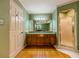 Spacious bathroom featuring a wooden vanity, large mirror, shower and hardwood flooring at 3290 Spain Rd, Snellville, GA 30039
