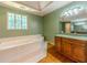 Large soaking tub is the focus of this bathroom with hardwood floors, a sink, and decorative window at 3290 Spain Rd, Snellville, GA 30039