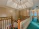 Well-lit upstairs hallway with green carpet, a decorative chandelier, and wood and white railing at 3290 Spain Rd, Snellville, GA 30039