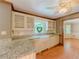 Bright kitchen features granite countertops, white cabinets and farmhouse sink at 3290 Spain Rd, Snellville, GA 30039