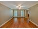 Well-lit living room featuring hardwood floors, plantation shutters, and a ceiling fan at 3290 Spain Rd, Snellville, GA 30039